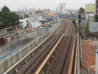 同じ歩道橋から新宿方面の線路を見る。架線の一部は取り外されている。